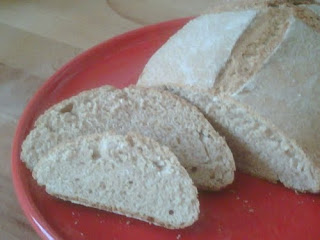 Hogaza de pan en pirex con dos rebanadas cortadas.
